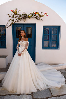 Full-length ivory wedding dress with floral lace sleeves, an A-line silhouette, and a long train