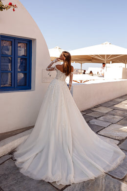 Back view of an ivory wedding dress with lace sleeves, a flowing skirt, and an extended train