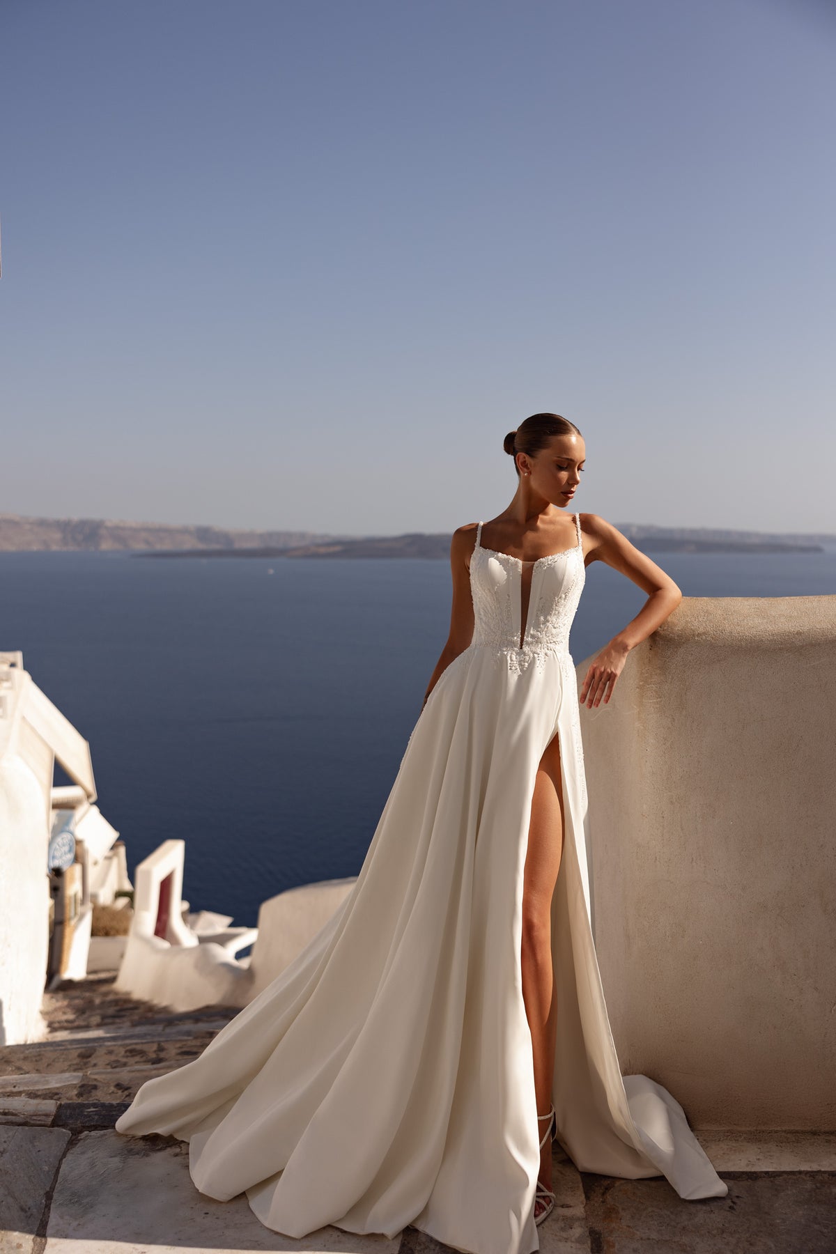 Full-length ivory wedding dress with a beaded lace bodice, high front slit, and sweeping train
