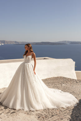 Ivory A-line wedding dress with beaded lace bodice, thin straps, and a flowing full skirt