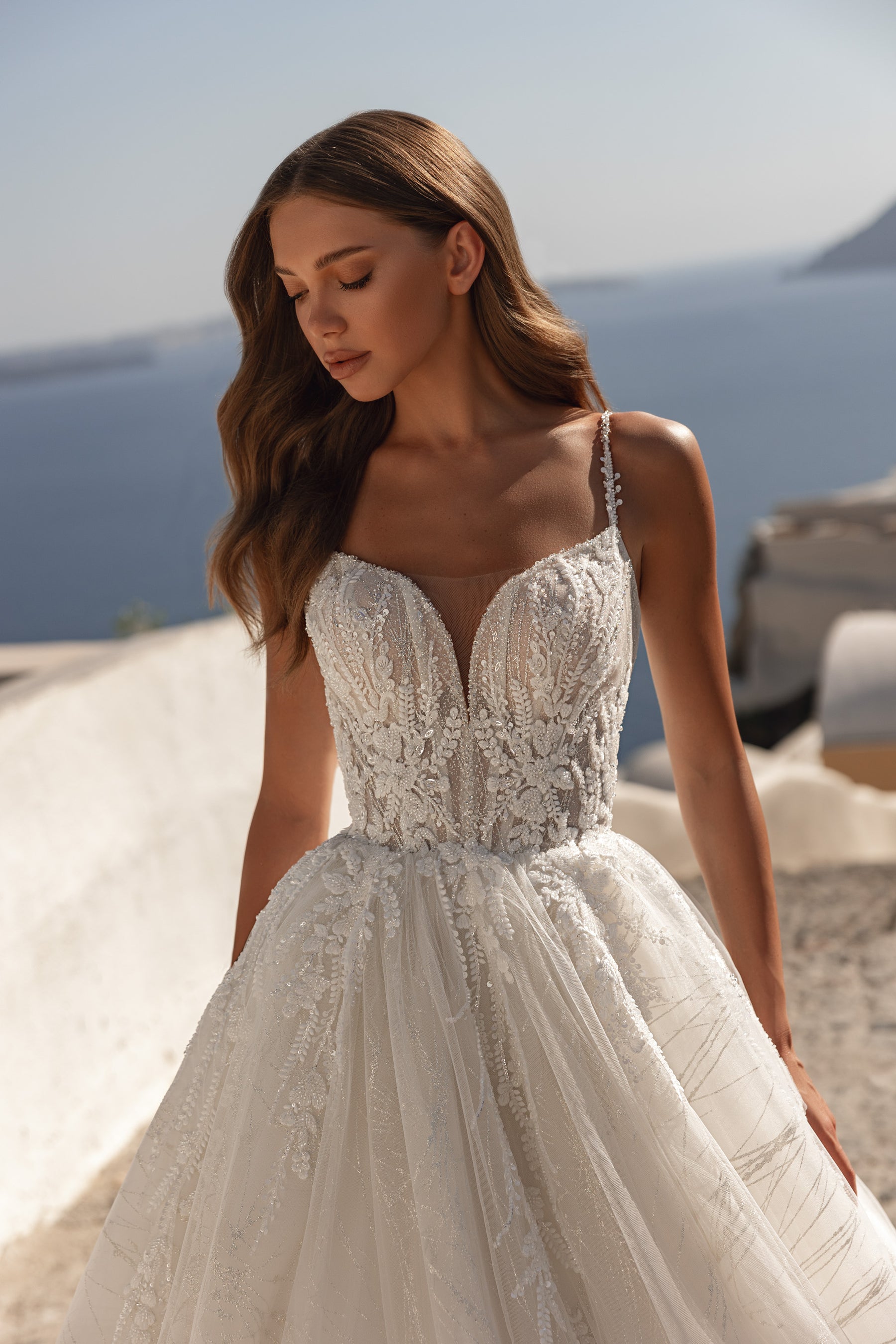 Close-up of a wedding dress bodice with beaded lace, a plunging sweetheart neckline, and thin straps