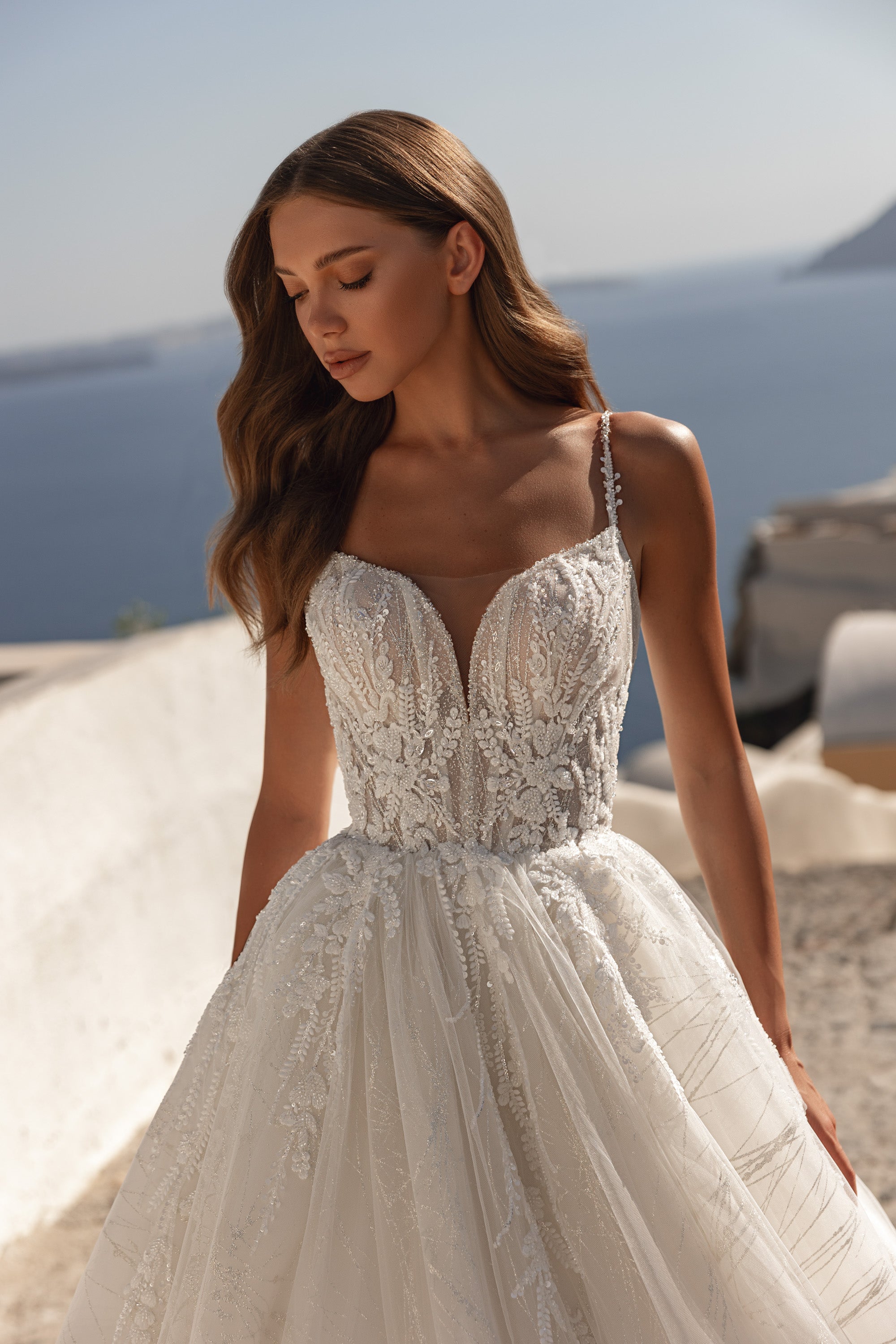 Close-up of a wedding dress bodice with beaded lace, a plunging sweetheart neckline, and thin straps