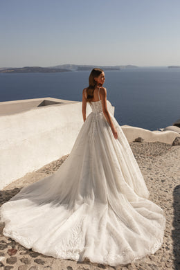 Open-back ivory wedding dress with delicate straps, beaded lace details, and a sweeping train
