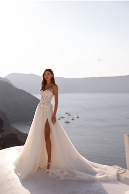 Ivory wedding dress with a strapless lace bodice, high slit, flowing overskirt, and extended train