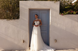 Ivory wedding dress featuring a sheer beaded neckline, long sleeves, A-line skirt, and extended train