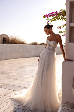 Ivory wedding dress with a sweetheart bodice, sparkling beadwork, A-line skirt, and sweeping train