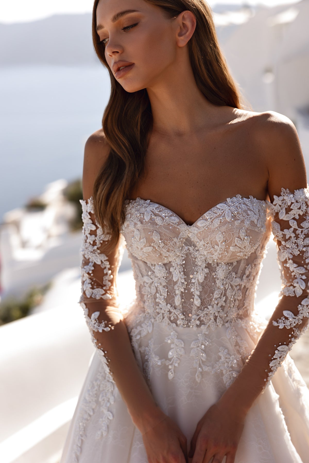 Ivory wedding dress with a sweetheart neckline, off-shoulder sheer lace sleeves, and an embellished floral-lace bodice