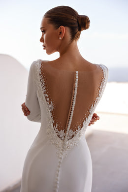 Deep V illusion back with lace edging and covered buttons on an ivory wedding dress