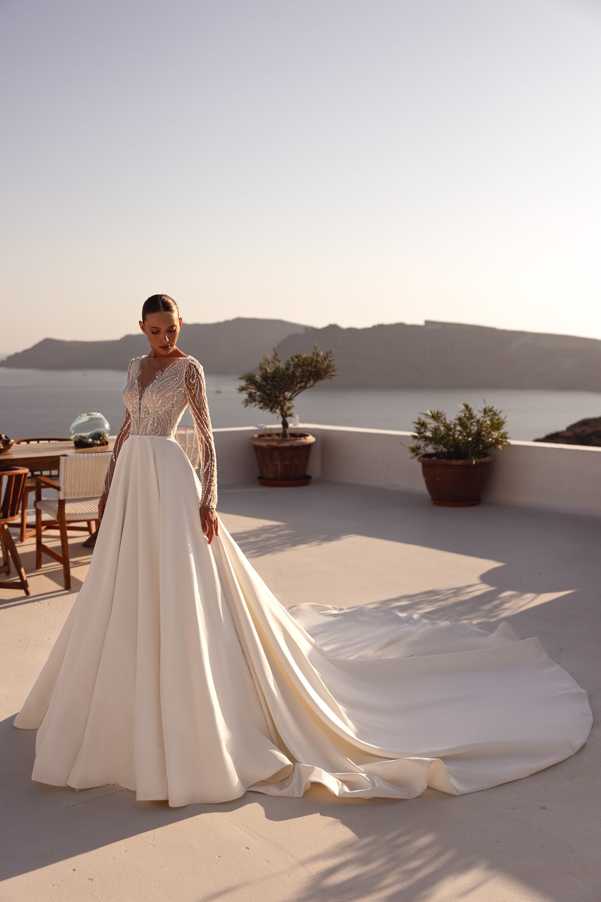 Ivory A-line wedding dress with a beaded illusion bodice, long sleeves, and sweeping train