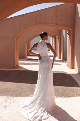 Lace-covered back and long trailing hem on a fitted ivory wedding dress
