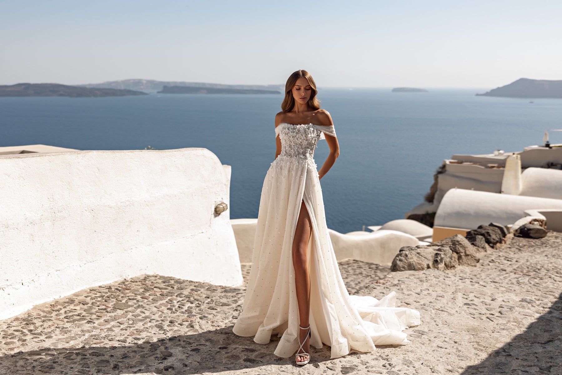 Off-the-shoulder ivory wedding dress with a beaded bodice, A-line skirt, and high front slit