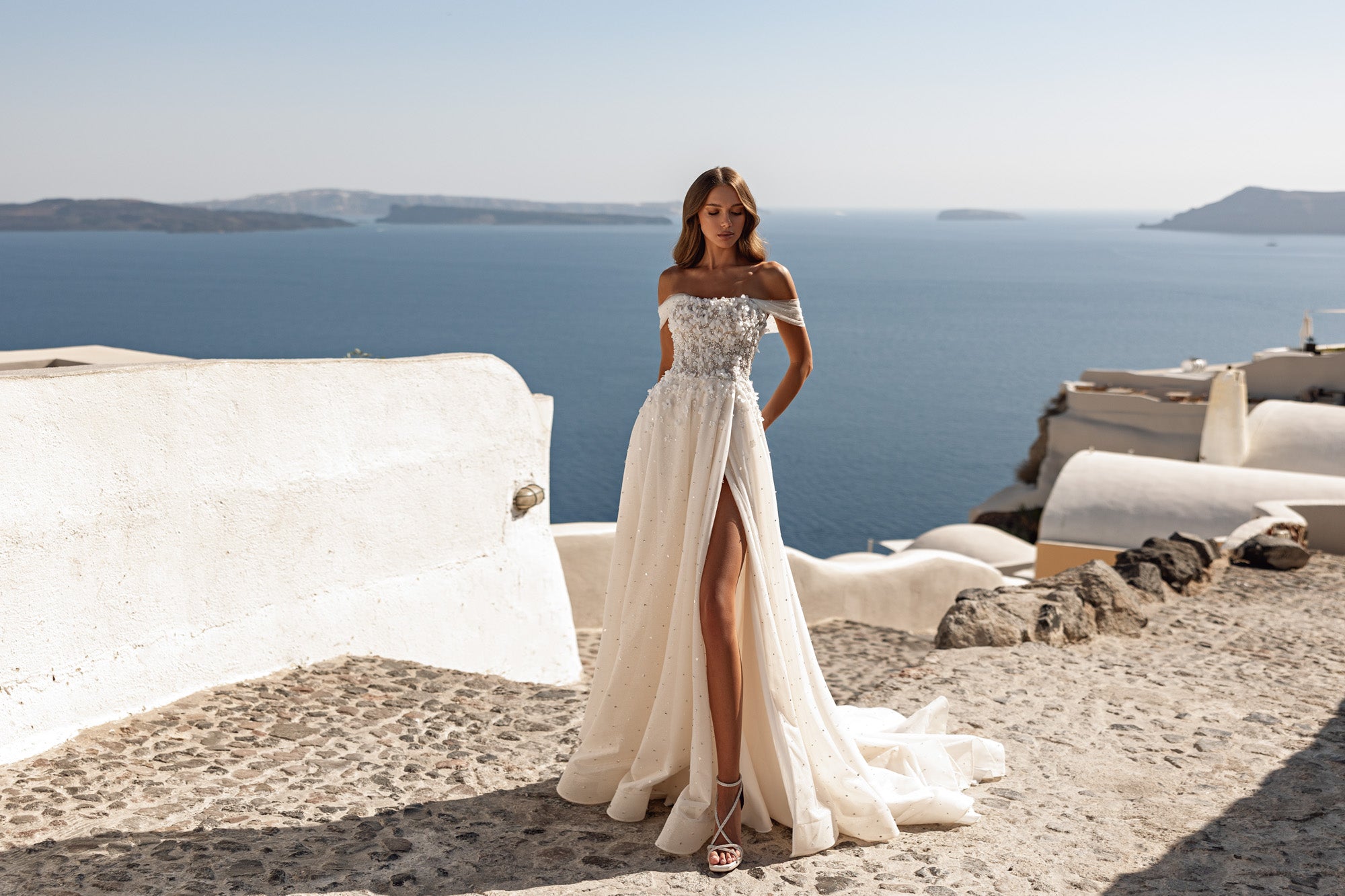 Off-the-shoulder ivory wedding dress with a beaded bodice, A-line skirt, and high front slit