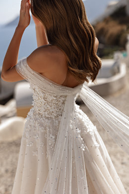 Embellished ivory wedding dress with an open back and draped off-the-shoulder sleeves