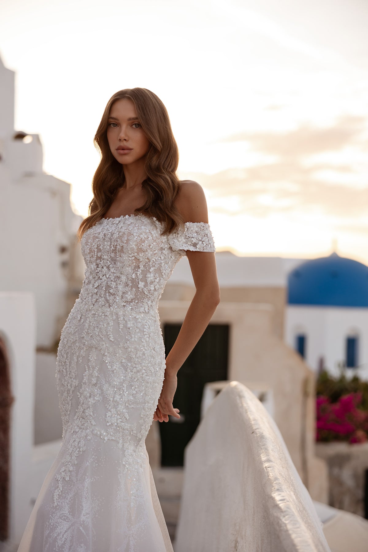 Ivory mermaid wedding dress with an off-the-shoulder neckline and allover sparkling lace
