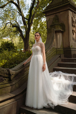 Ivory A-line wedding dress with a sweetheart bodice, pearl-embellished illusion neckline, and sheer long sleeves