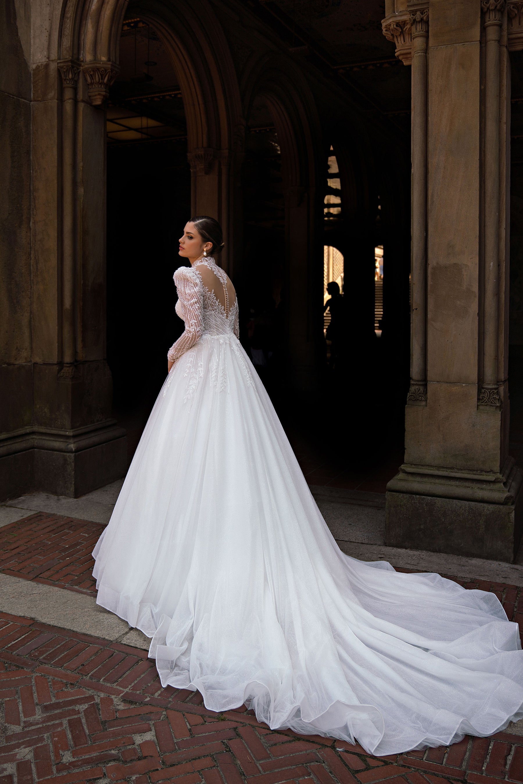 Sheer beaded back and sweeping train on a white A-line wedding dress with long sleeves