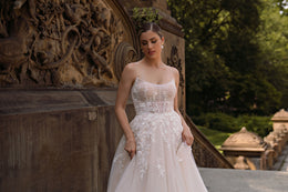 Close-up of floral appliqués and sparkling beadwork on the bodice of an ivory wedding dress
