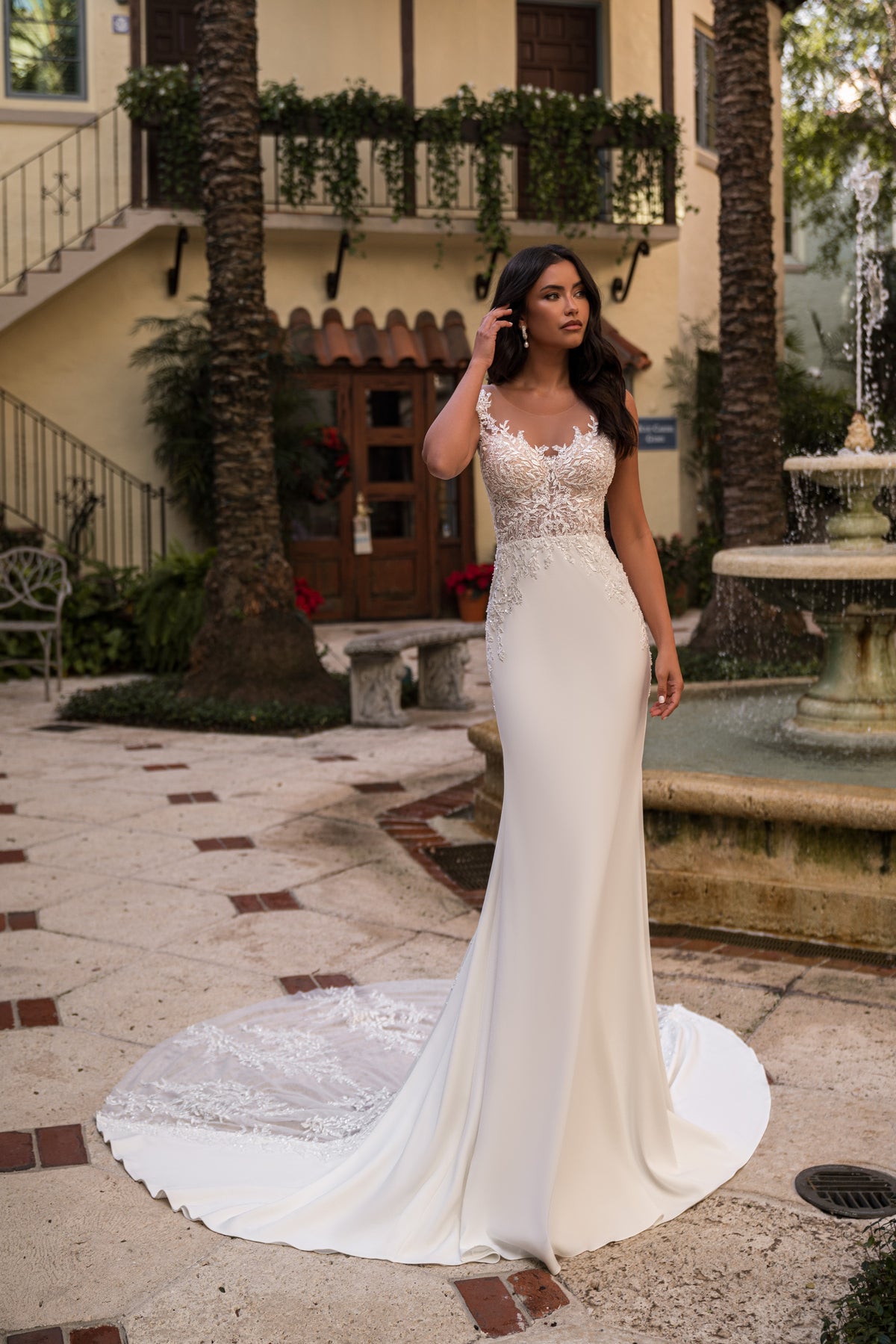 Ivory sheath wedding dress with an illusion lace bodice, fitted skirt, and sweeping train
