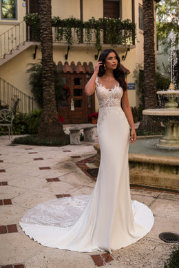 Ivory sheath wedding dress with an illusion lace bodice, fitted skirt, and sweeping train