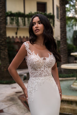Close-up of floral lace appliqués and an illusion neckline on a fitted wedding dress