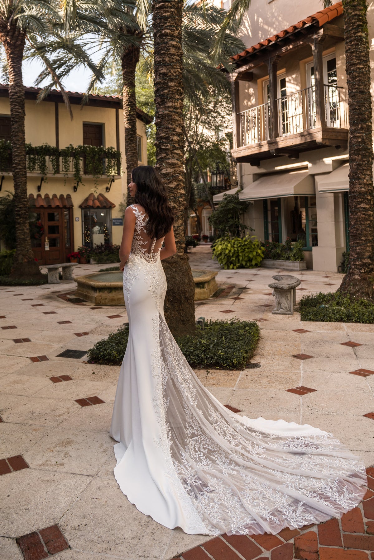 Lace illusion back and extended train on an ivory sheath wedding dress