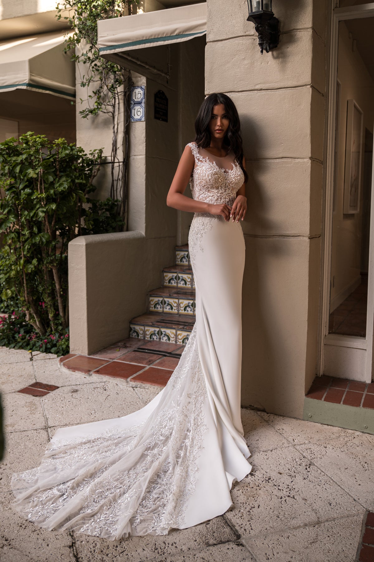 Ivory wedding dress with a fitted silhouette, lace-detailed train, and illusion lace bodice
