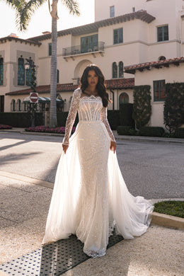 Ivory wedding dress with a fitted beaded skirt and detachable sheer overskirt flowing from the waist