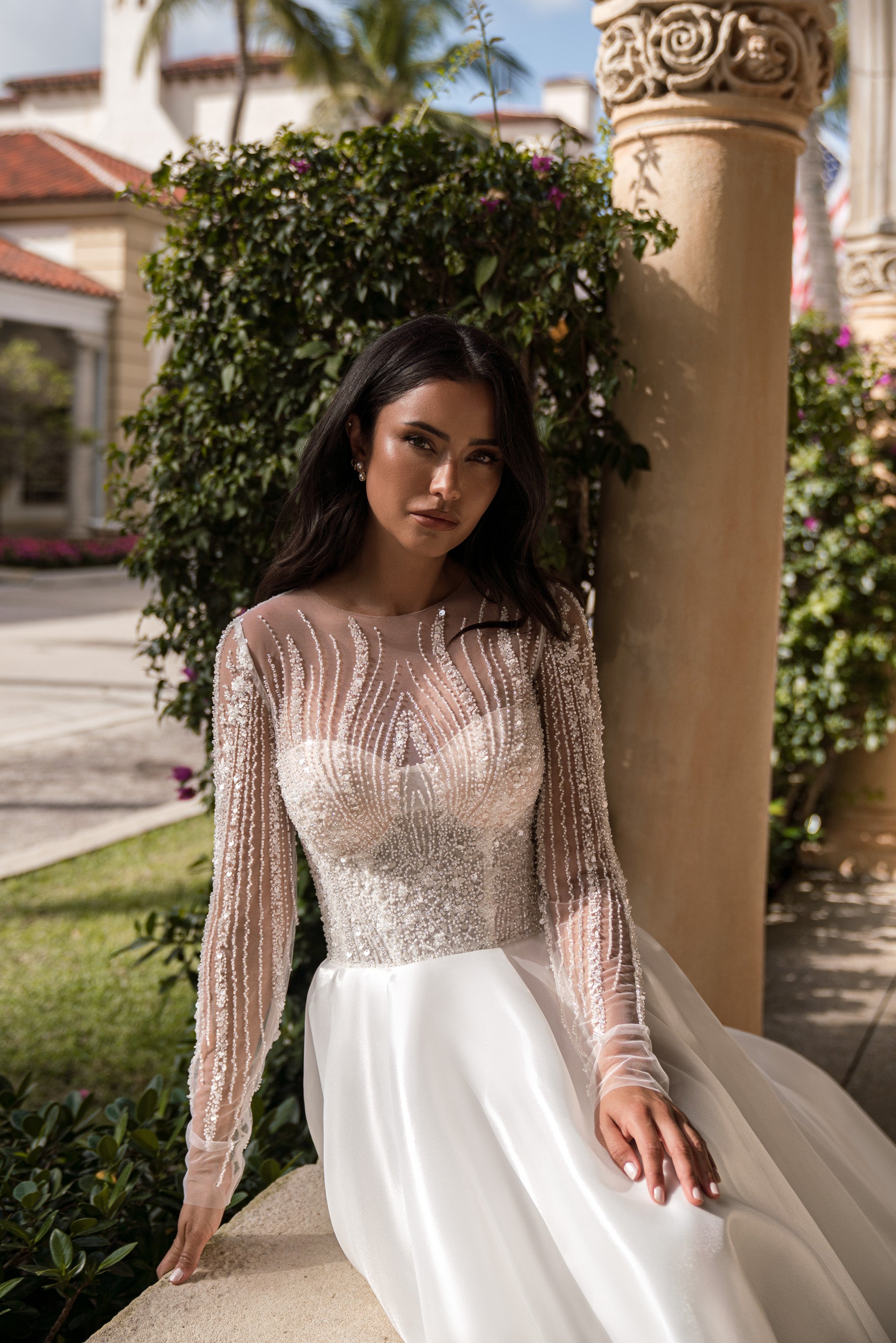 Beaded illusion long-sleeve wedding dress with a fitted bodice and full ivory skirt