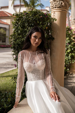 Beaded illusion long-sleeve wedding dress with a fitted bodice and full ivory skirt