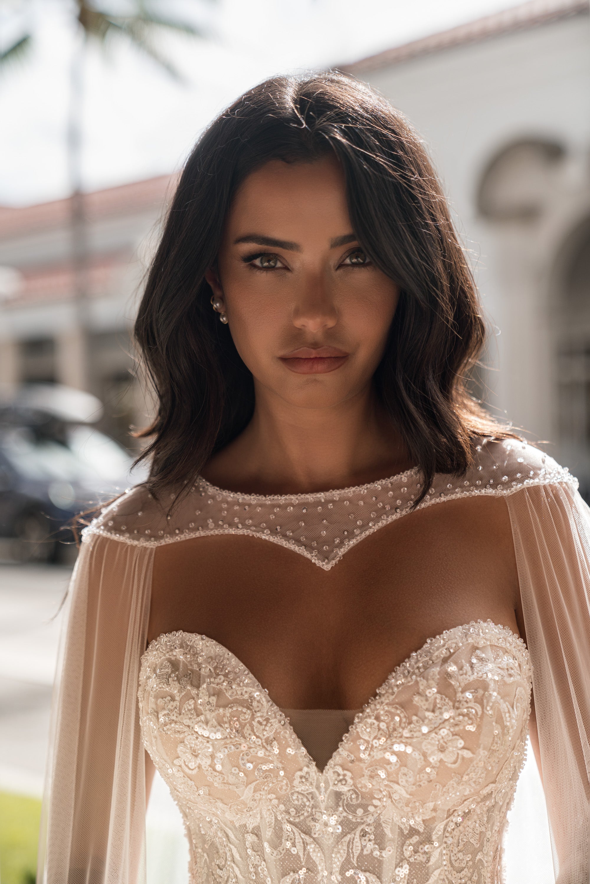 Close-up of the beaded sweetheart bodice and sheer embellished cape neckline on a wedding dress