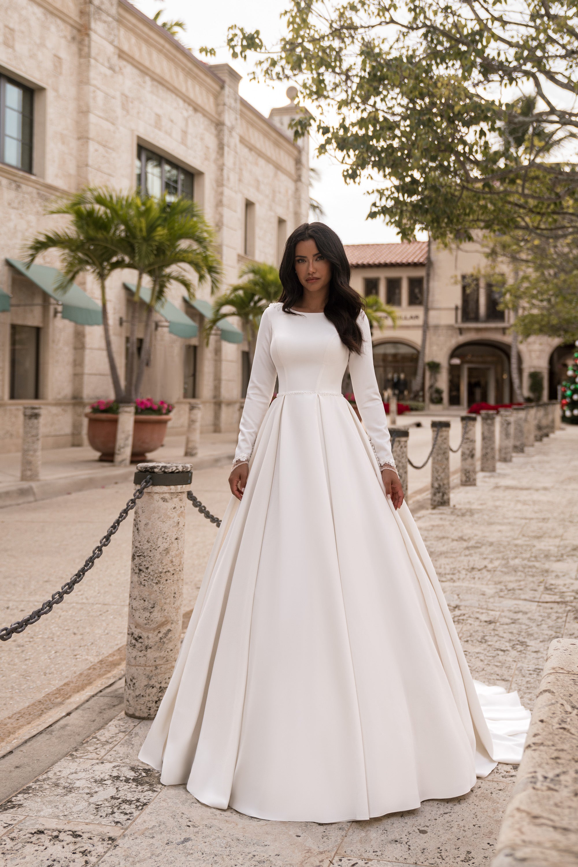 Full ivory A-line wedding dress with long sleeves, a high neckline, and a wide flowing skirt