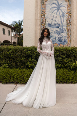 Ivory A-line wedding dress with long sheer lace sleeves, high neckline, and a flowing train