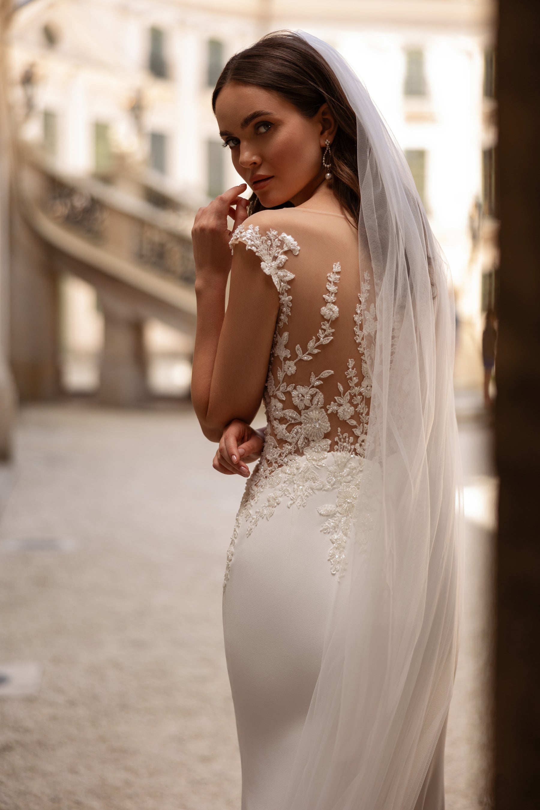 Ivory wedding veil with floral lace appliqués along the edge and a long trailing length