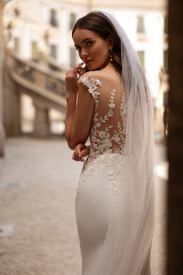 Ivory wedding veil with floral lace appliqués along the edge and a long trailing length
