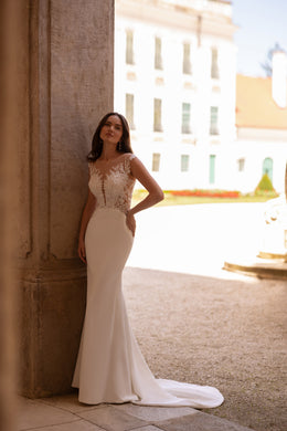 Ivory sheath wedding dress with an illusion lace bodice and sweeping train