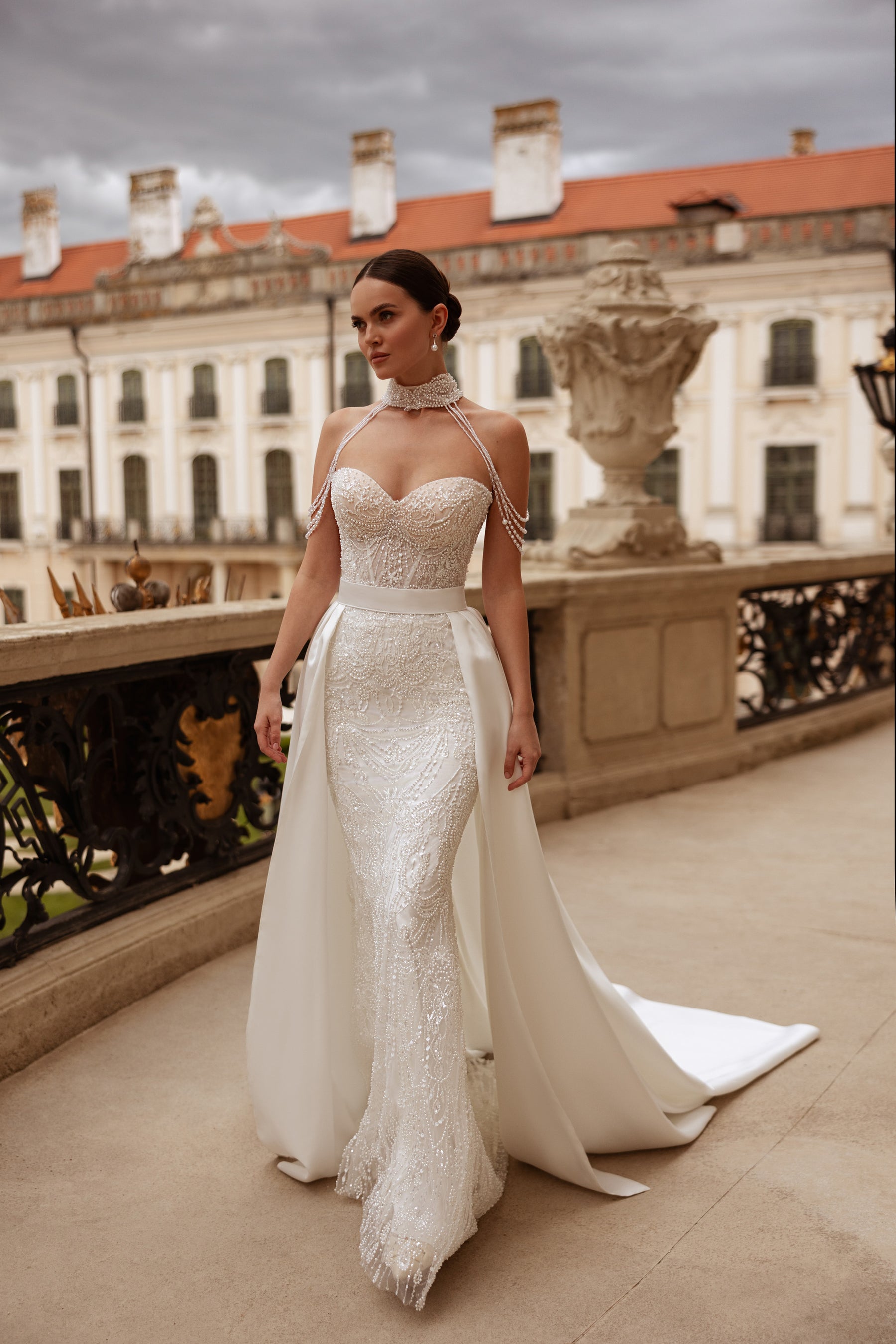 Beaded ivory wedding dress with a sweetheart neckline, fitted sheath silhouette, and detachable overskirt