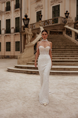 Fitted ivory wedding dress featuring a sparkling beaded bodice, sweetheart neckline, and narrow sheath skirt