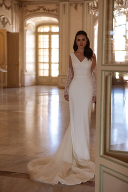 Fitted ivory wedding dress with a V-neckline, sheer lace sleeves, and a sweeping train