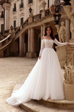 Ivory A-line wedding dress with an off-the-shoulder lace neckline, long sleeves, and a sweeping train