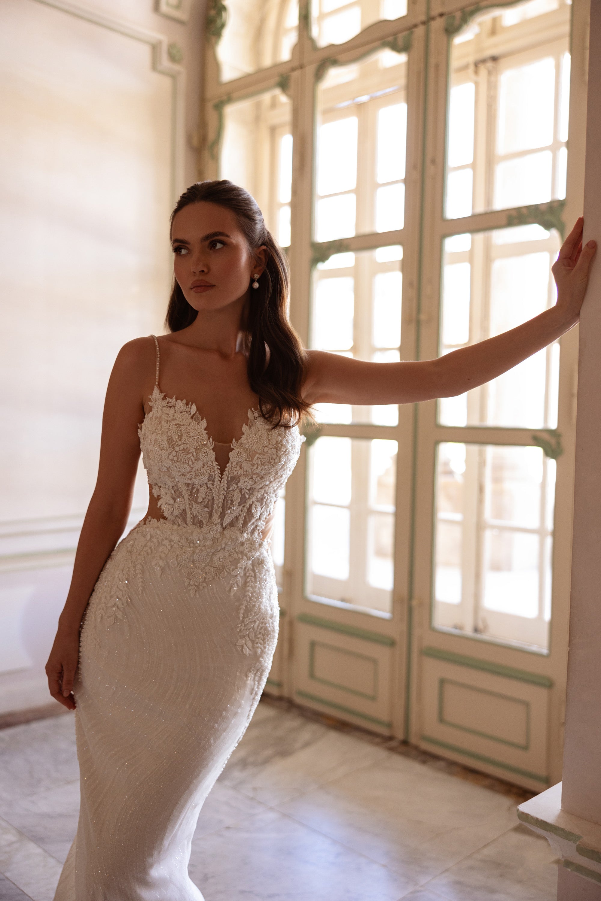 Ivory mermaid wedding dress featuring a plunging V-neckline, thin straps, and sparkling beaded lace