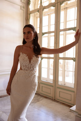 Ivory mermaid wedding dress featuring a plunging V-neckline, thin straps, and sparkling beaded lace