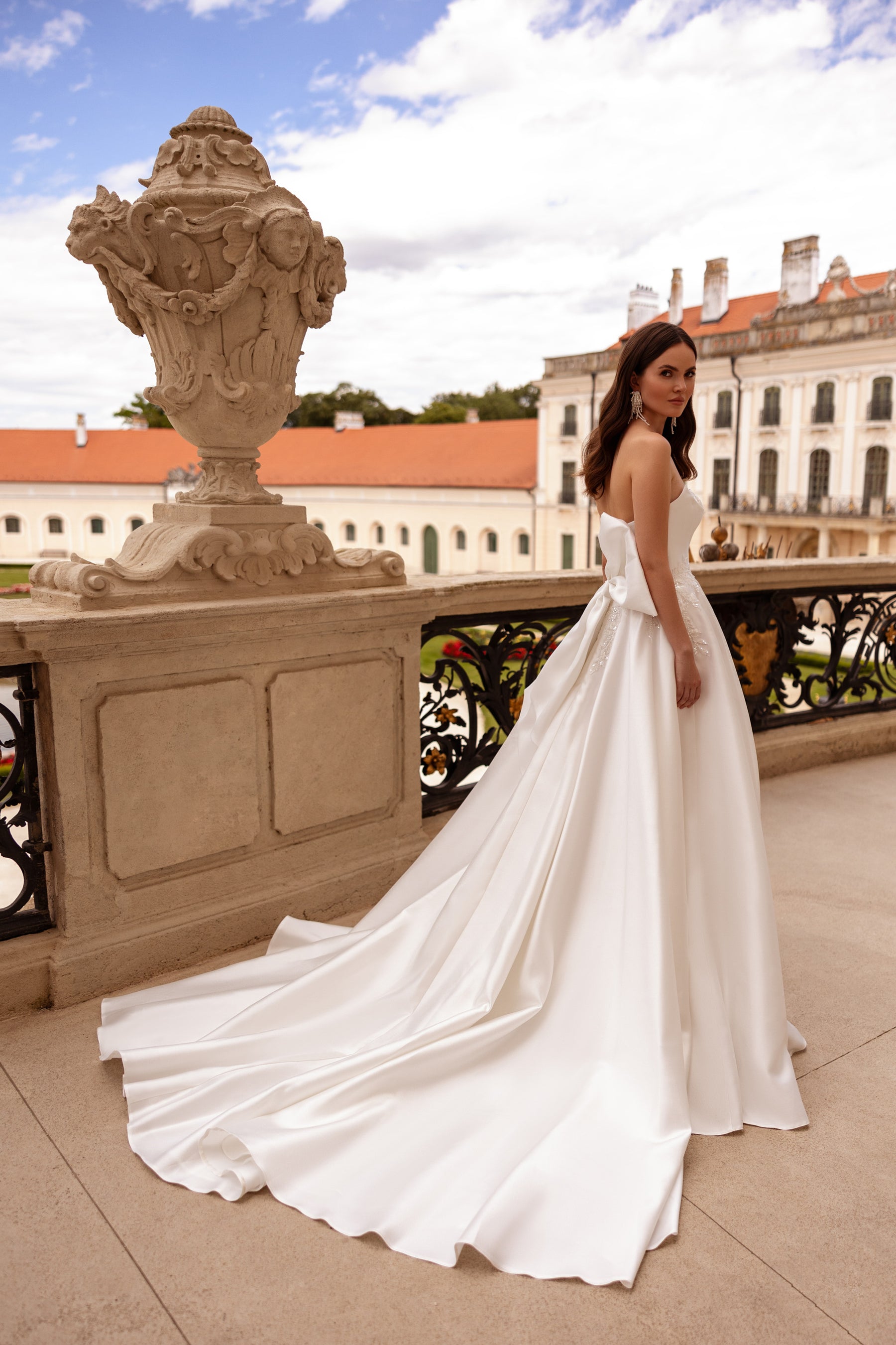 Side profile of an ivory strapless wedding dress with a fitted bodice and long train