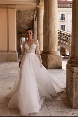 Ivory A-line wedding dress with a sheer lace bodice, long sleeves, and a full flowing skirt