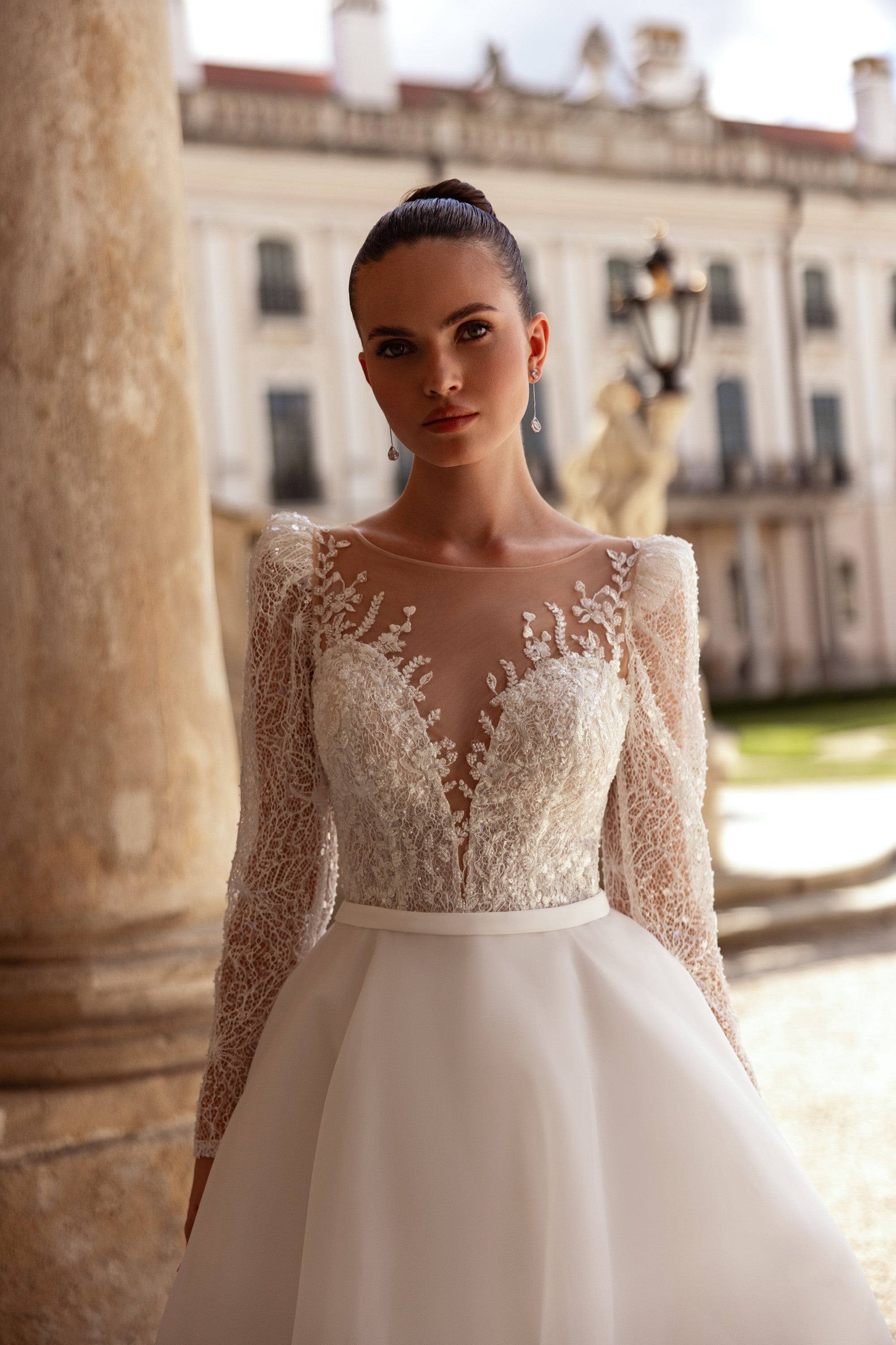 Wedding dress featuring a sheer illusion neckline, floral lace bodice, long sleeves, and an A-line skirt