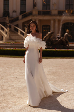 White wedding dress with a sweetheart neckline, floral off-shoulder sleeves, and a sweeping train
