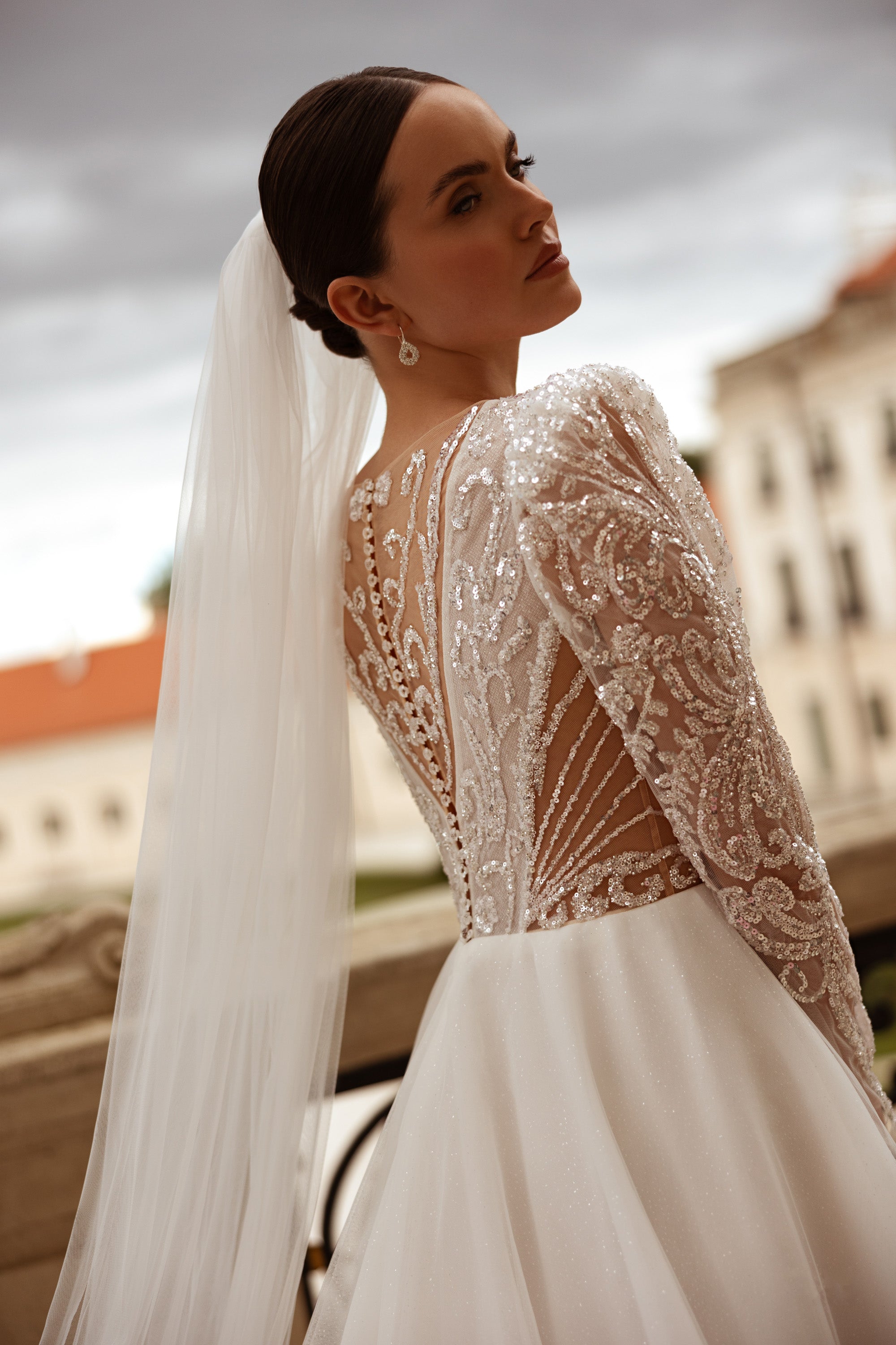 Beaded lace back with a deep V opening and long sheer sleeves on an ivory wedding dress