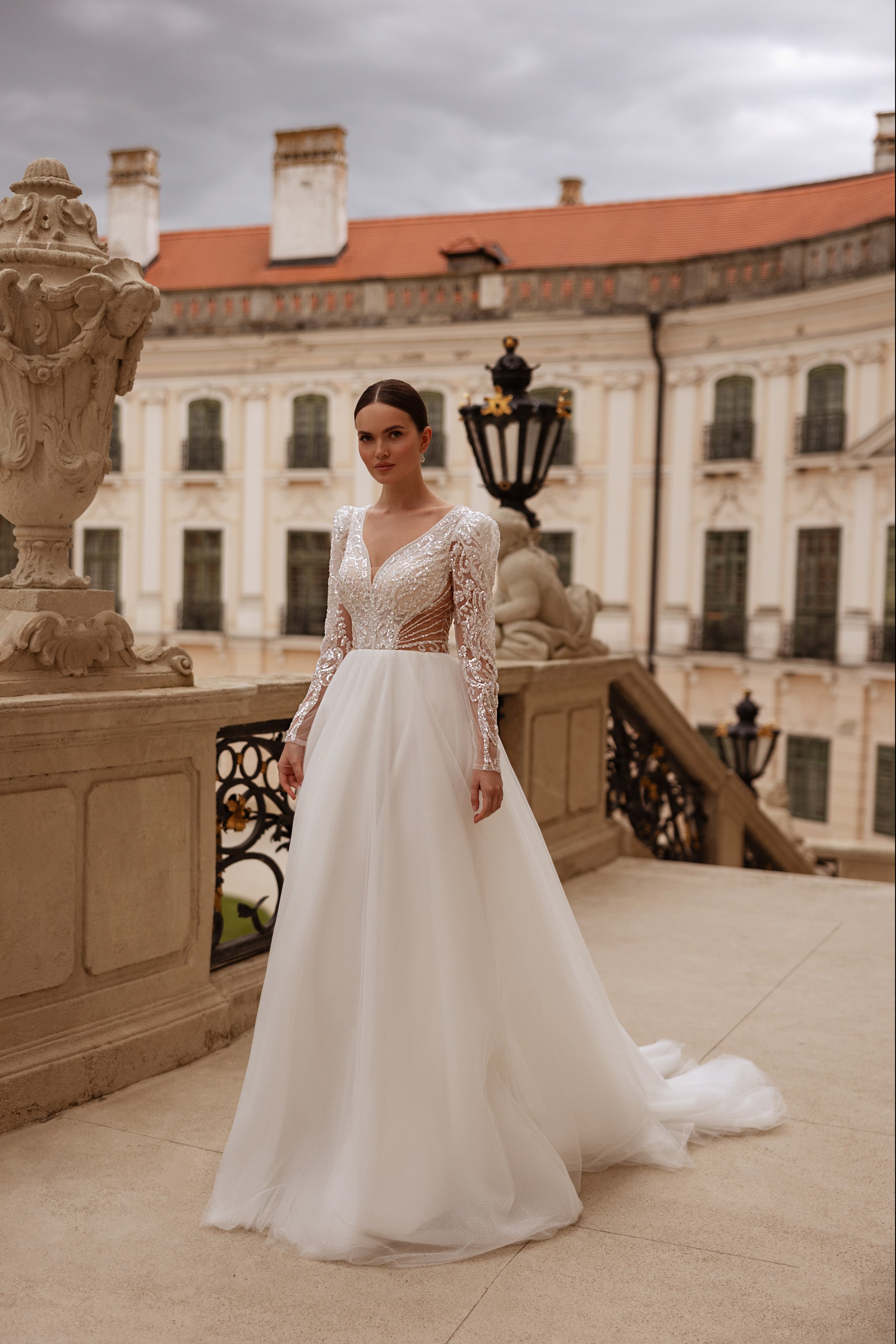 Ivory A-line wedding dress with long illusion lace sleeves, beaded bodice, and flowing train