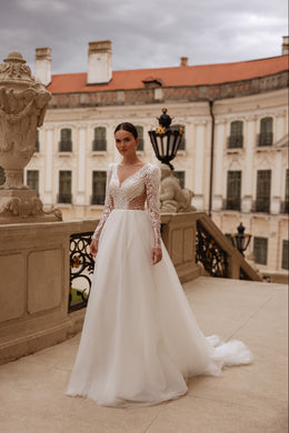 Ivory A-line wedding dress with long illusion lace sleeves, beaded bodice, and flowing train