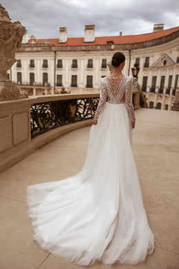 Illusion lace V-back and long sleeves on an ivory wedding dress with a sweeping train