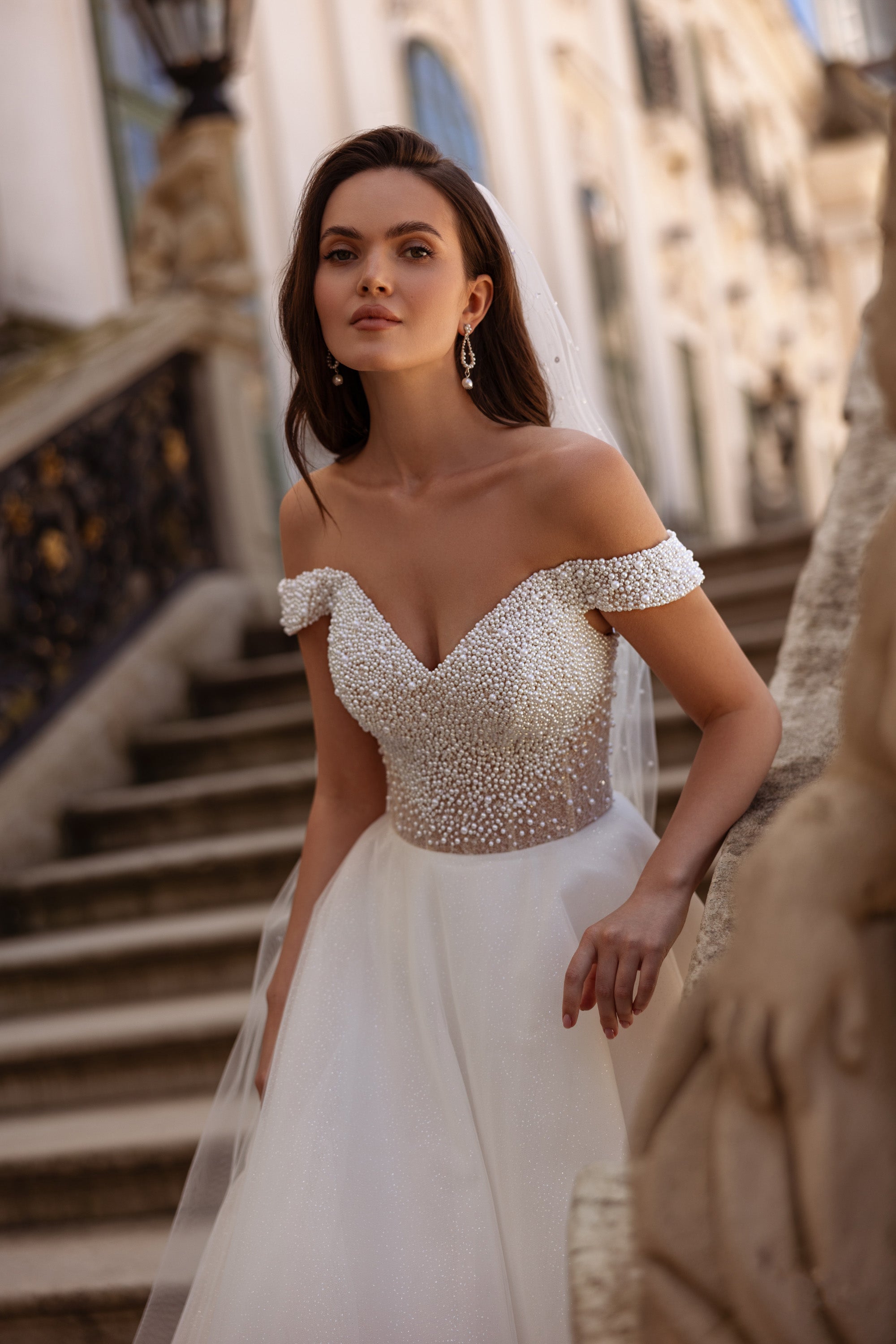 Sweetheart wedding dress with dense pearl beadwork, off-shoulder sleeves, and a full ivory skirt